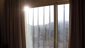 A window with a view of a hilly landscape.