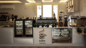 A coffee shop interior with a counter, coffee machines, and a display case.