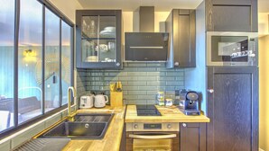 A modern kitchen with a built-in oven, a coffee maker, and a microwave. - Brousse & Brise - Studio à deux pas de la mer (Arcachon)