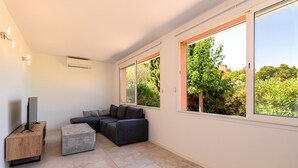 Una sala moderna con un sofá modular, una mesa de centro y un televisor de pantalla plana sobre un mueble de madera.
