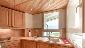 Une cuisine avec des meubles en bois, un évier et une fenêtre donnant sur un beau paysage.