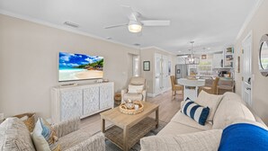 Ein Wohnzimmer mit Fernseher, Sofa und Couchtisch.