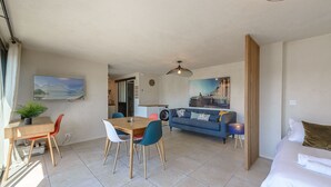 Een moderne woonkamer met een eethoek, een bank en een bed.