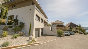 Een modern huis met twee verdiepingen, een garage, een oprit en uitzicht op zee.