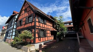 Un edificio tradizionale con struttura a telaio in legno e un vialetto in pietra che conduce a una scala.