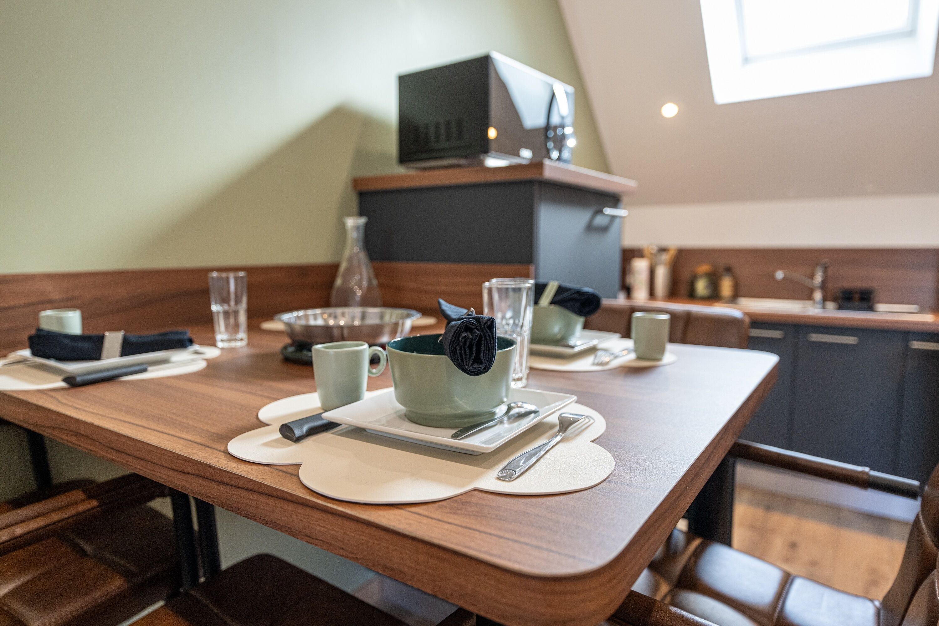 A dining table set with plates, cutlery, and a cup.