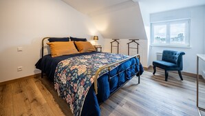 A bedroom with a bed, a chair, a window, and a lamp. - Le Tripot - A 15 min de la plage (Montebourg)