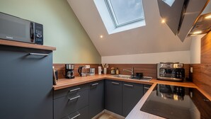 A modern kitchen with a built-in microwave, coffee maker, and toaster. - Le Tripot - A 15 min de la plage (Montebourg)