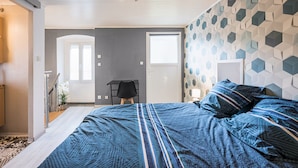 A bedroom with a bed, a desk, a chair, and a door. - La Belle Maurienne - Balcon avec vue sur montagne (Saint-Etienne-de-Cuines)