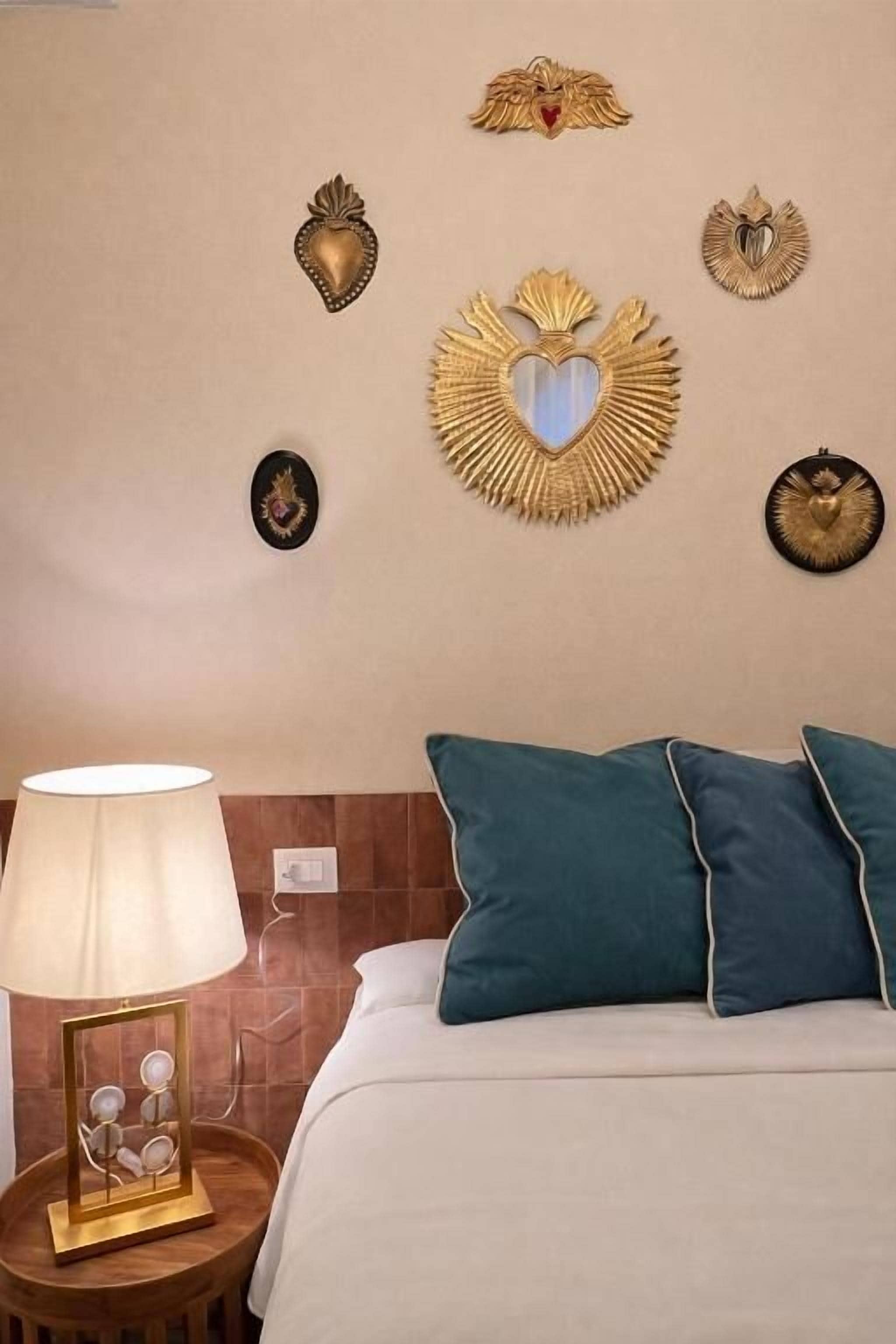A hotel room with a bed, a bedside lamp, and decorative wall art.