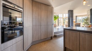 Una cocina moderna con electrodomésticos integrados, una isla grande y vistas al exterior.