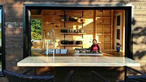 Una cocina moderna con un ventanal grande, armarios de madera y un hervidor.