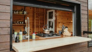 Una cocina con estufa a gas, hervidor y diversos utensilios.