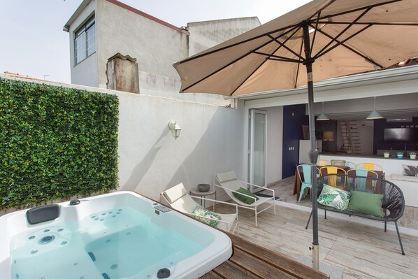 A hot tub, outdoor seating, and a kitchen area.