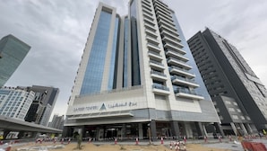 Ein hoch aufragendes Gebäude mit modernem architektonischem Design, das eine markante Eingangshalle und mehrere Balkone aufweist.