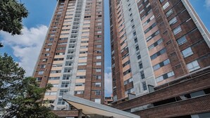 Un immeuble de grande hauteur au design moderne, comprenant de nombreux étages et une entrée imposante.