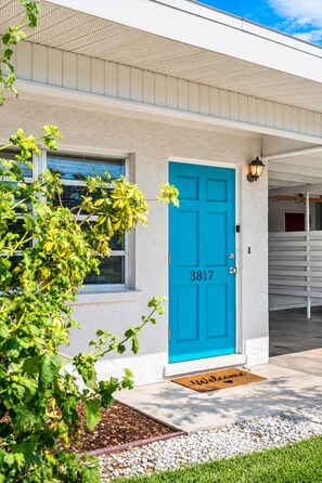 A building with a blue door, a window, and a doorbell. - Private Coastal Haven: Fire Pit • Yard • Beach (Sarasota)