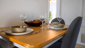 A dining table with two bowls, two wine glasses, and a loaf of bread. - Chic Local Hideaway: Yard |BBQ Nights | Near Beach (Sarasota)