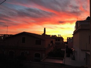 Un atardecer sobre una zona residencial con edificios y una calle.