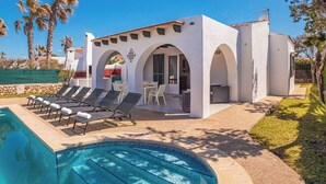 A modern building with a pool, sun loungers, and a patio area. - Villa Maype by 3 Villas Menorca (Cap d`Artrutx)