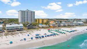 Ein Hotel an der Küste mit Blick auf den Strand, mehreren Etagen und verschiedenen Baustilen.