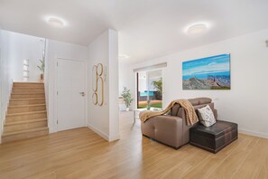 A modern interior with a staircase, a sofa, and a painting. - Home2Book Stylish House with Pool & Chill-out (Santa Lucia de Tirajana)