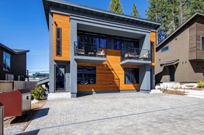 A modern two-story building with a wooden facade, large windows, and a balcony. - South Lake Tahoe 2 Bedroom 2 Bath (South Lake Tahoe)