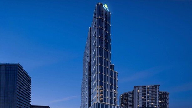 Moderni korkea hotellirakennus, jonka tunnusomaisena piirteenä on kaareva julkisivu, useita kerroksia ja huomiota herättävä kyltti katolla.