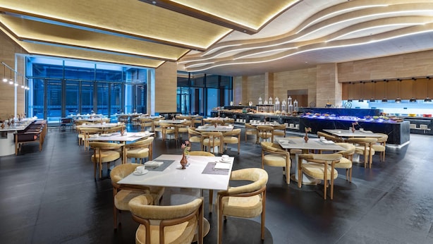 A spacious dining area with multiple tables and chairs, a modern ceiling design, and a large window providing a view of the cityscape. - Days Hotel By Wyndham Lishui Liandu (Lishui)