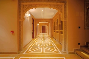 Un corridoio con archi elaborati e un motivo geometrico sul pavimento.