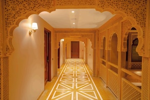 Un corridoio con archi decorati e un pavimento a motivi geometrici.