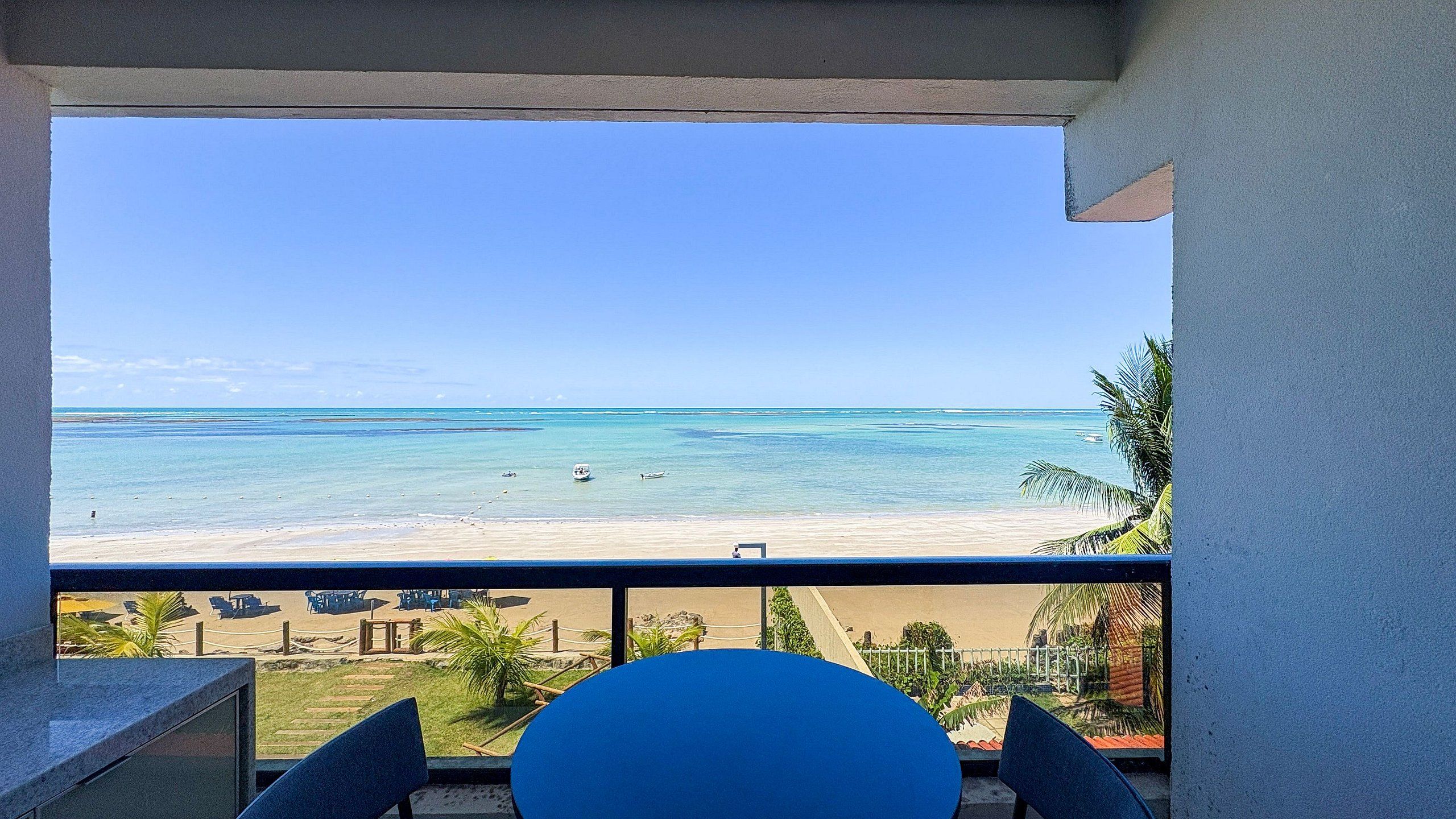 A balcony with a view of a beach and ocean.