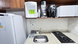A kitchen with a refrigerator, a coffee maker, a blender, a microwave, a sink, and a gas stove. - Prime Beach Tamandaré (Tamandaré)