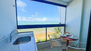 A balcony with a view of the beach, a sink, and two wicker chairs. - Prime Beach Tamandaré (Tamandaré)