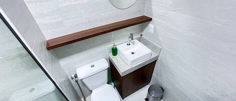 Un baño con inodoro, lavabo y espejo.