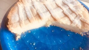 A pie with a lattice crust on a blue plate.