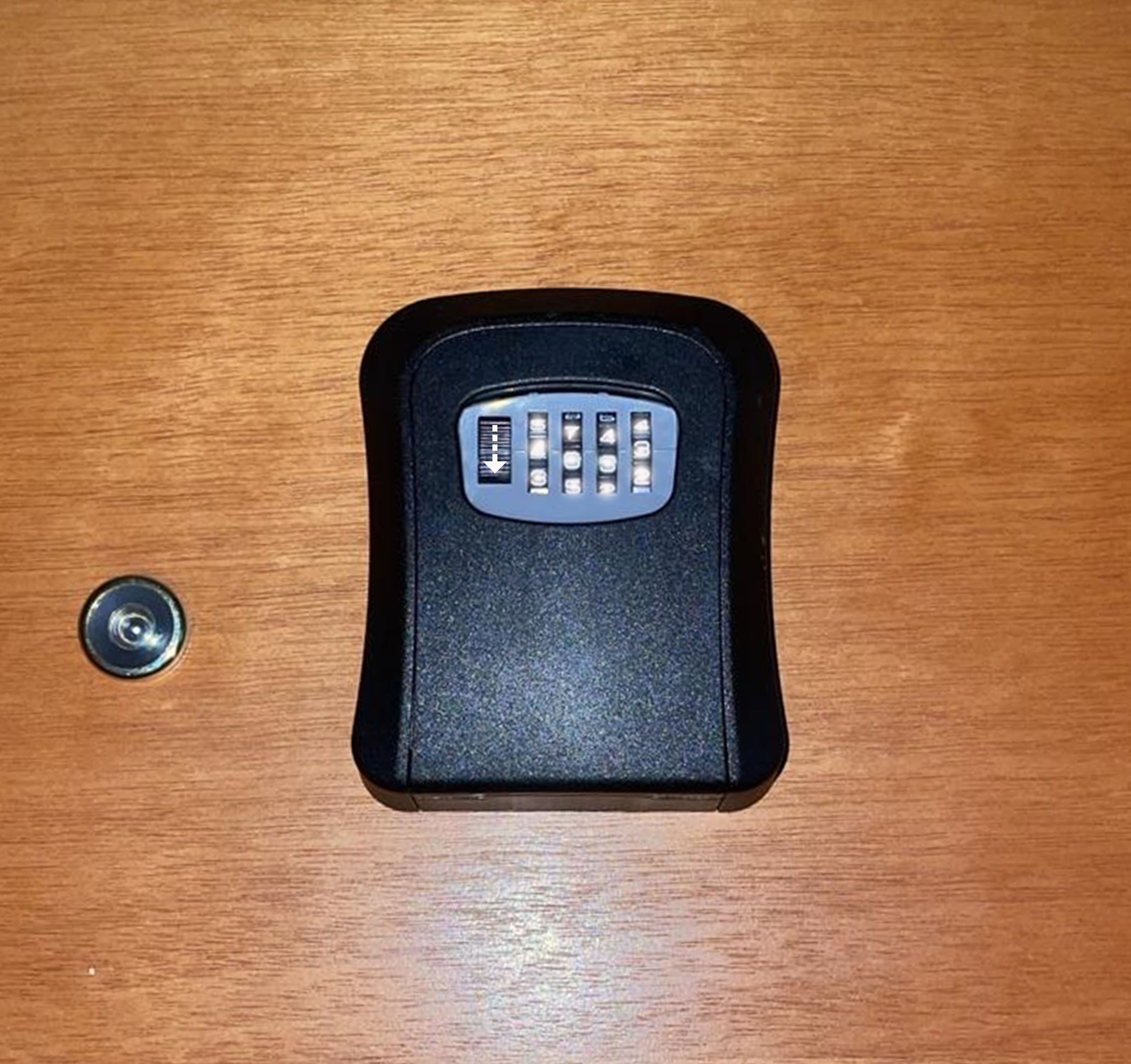A black remote control on a wooden surface.