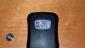 Un control remoto negro sobre una superficie de madera.