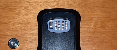 A black remote control on a wooden surface.