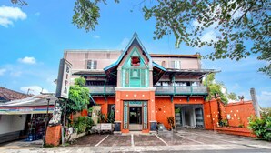 Un hôtel au style architectural traditionnel, caractérisé par une entrée imposante, une enseigne et un espace de stationnement situé à l’avant.
