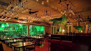 Un ristorante con diversi tavoli, lampadari e una grande vasca per pesci sullo sfondo.