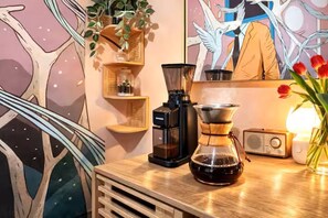 A coffee maker, a radio, and a plant on a wooden table. - Stunning + Quiet 1BR 1BA Soho Home w Plenty Storage (New York)