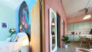 A bedroom with a bed, bedside lamp, and a wall mural. - Walk to Beach!「4 Bedroom」Vacation Home w Balcony! (Canals,)
