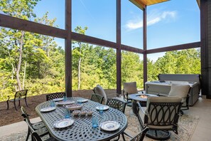 An outdoor patio with a table set for dining, surrounded by chairs, and a barbecue grill. - Fantastic 4-bedroom house with AC in charming Old Fort (Old Fort)