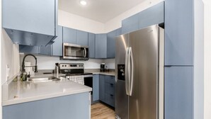 Una cucina moderna con elettrodomestici in acciaio inossidabile, un forno a microonde e un frigorifero.
