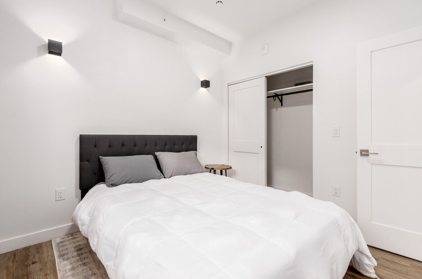 A bedroom with a bed, a bedside table, a wardrobe, and a closet.