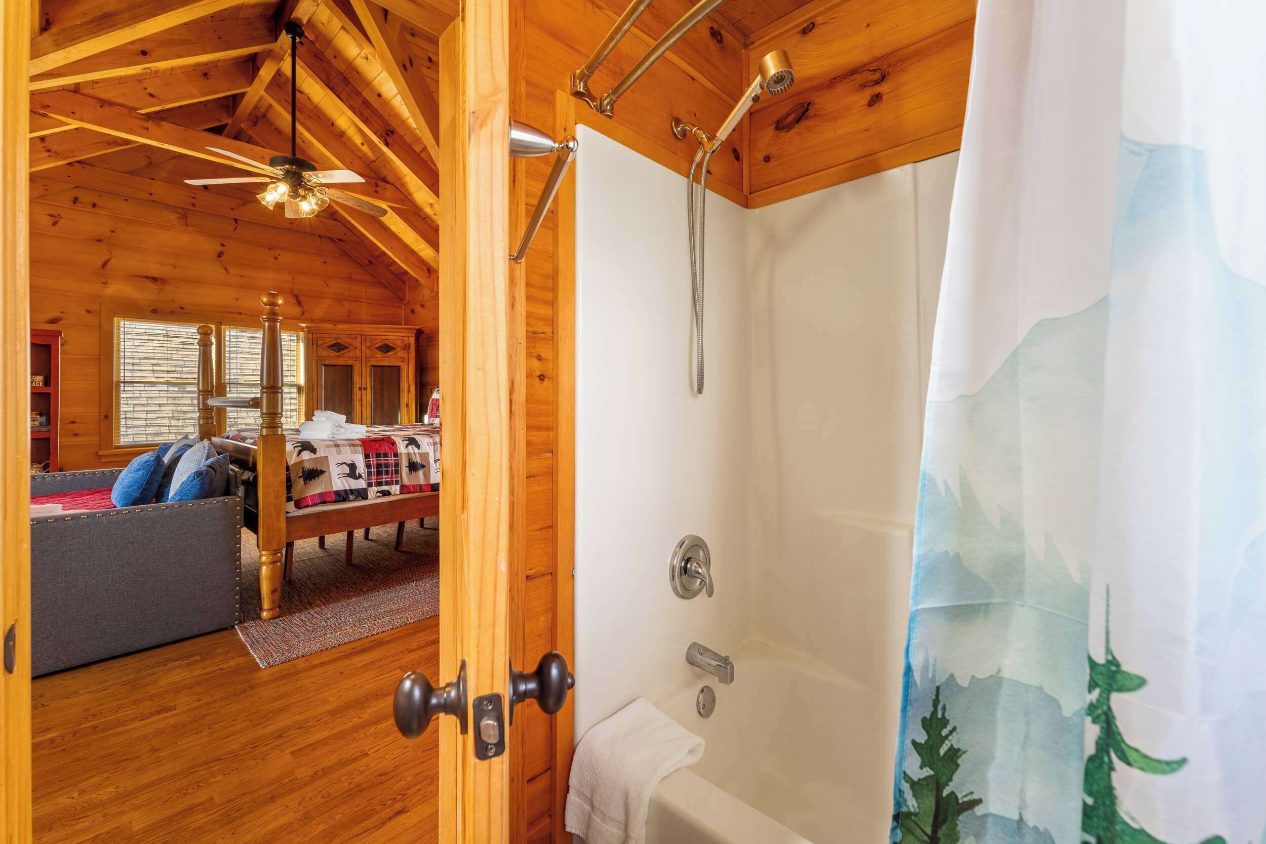 L’intérieur d’un chalet en bois comprend une chambre, une salle de bain avec douche et une porte visible.