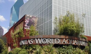 Außenansicht des Dallas World Aquariums mit großer Glasfassade und Beschilderung.