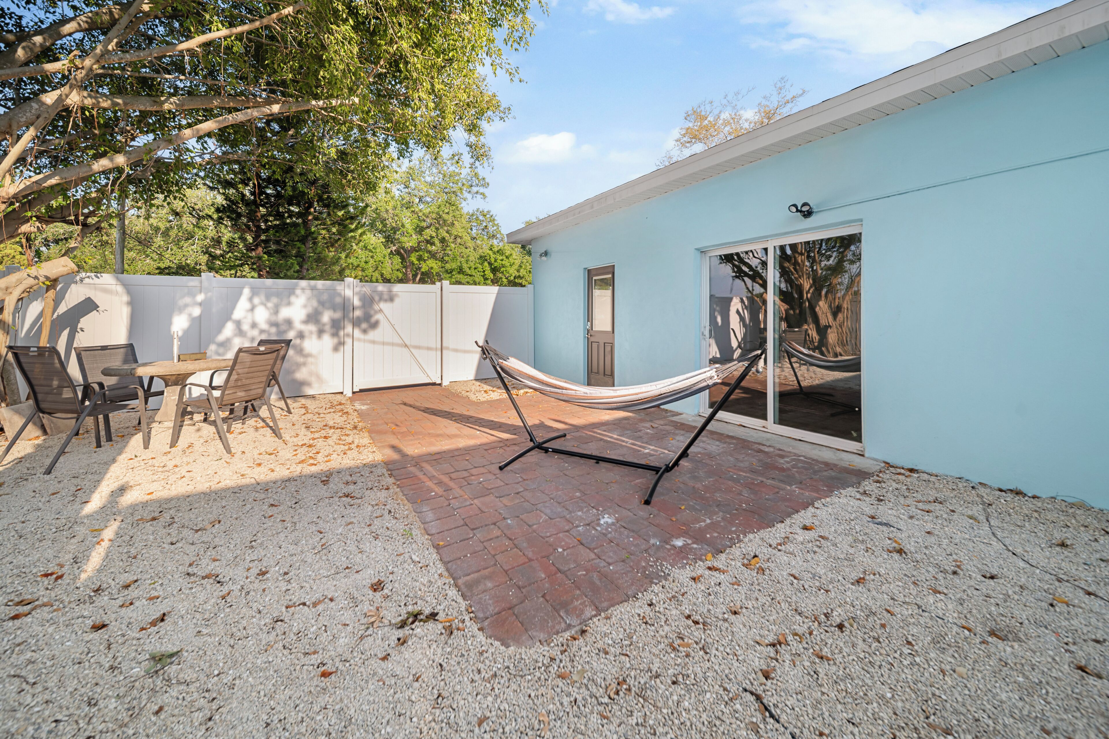 Eine Terrasse mit Hängematte, Tisch und Stühlen.