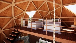 A wooden dome structure with a loft bedroom, a staircase, and a small seating area.